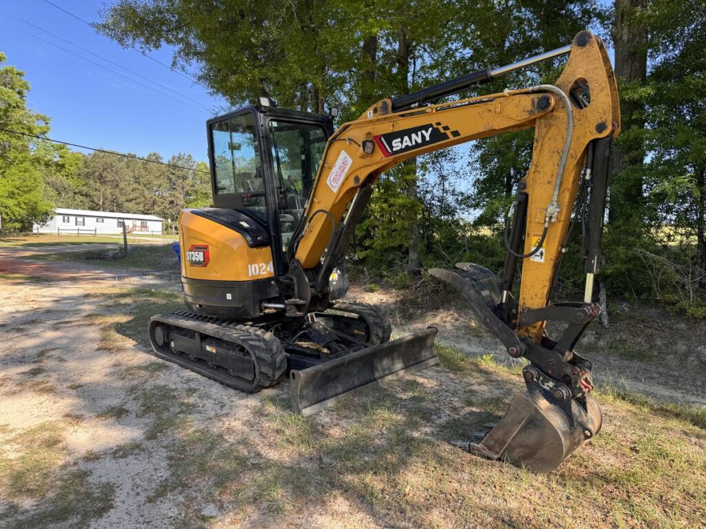 Mini excavator with rubber tracks and dozer blade, available to rent in Enterprise, AL
